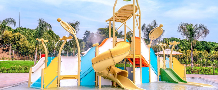 Im Kinderpool sorgen bunte Rutschen und spielerische Wasserspeier für lebendige Bewegung.